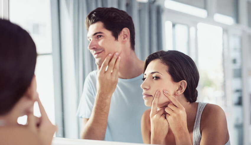 woman and man looking in the mirror
